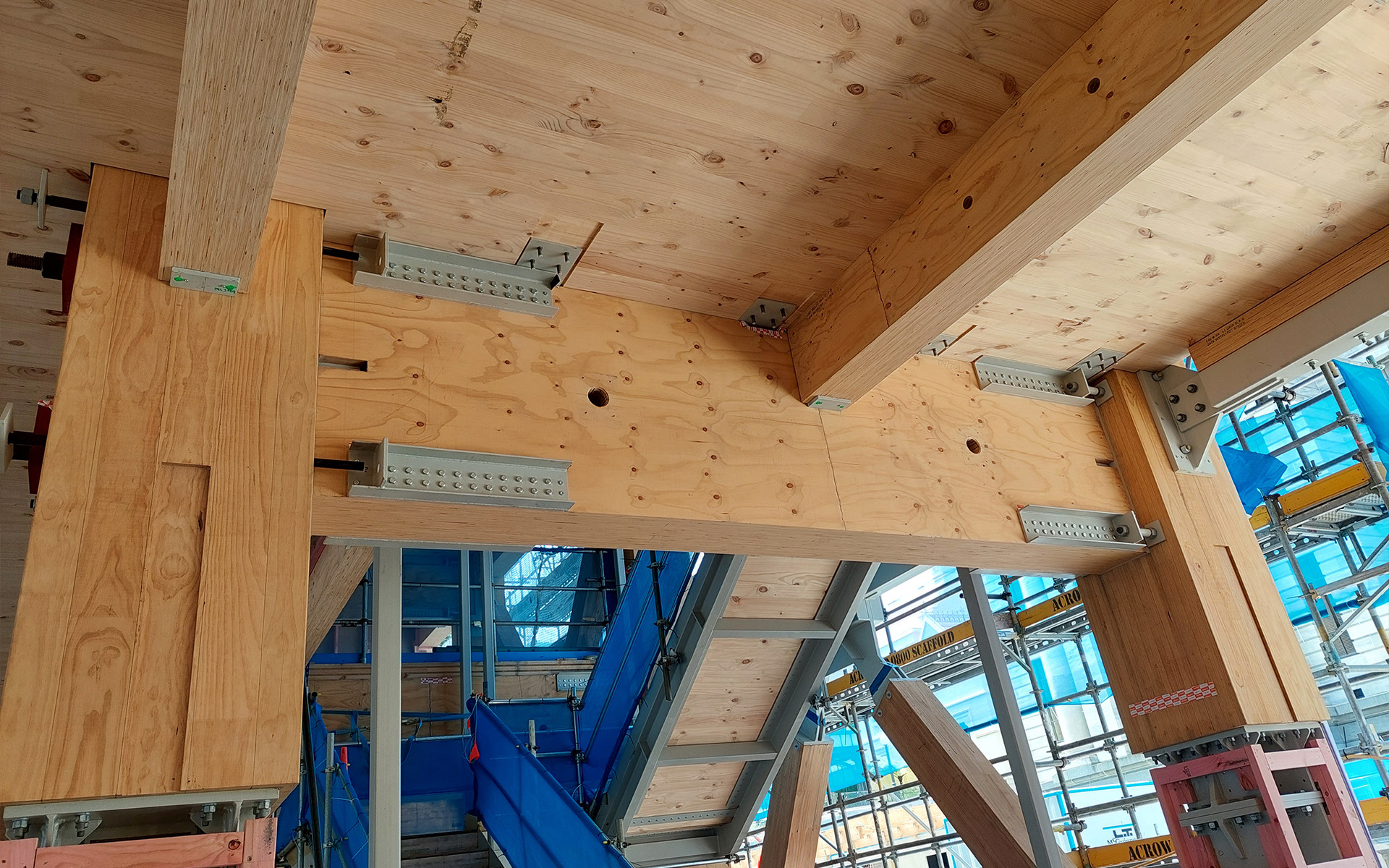 Mass timber beam-to-column connection with exposed hardware illustrating low-carbon construction and design for assembly techniques. 