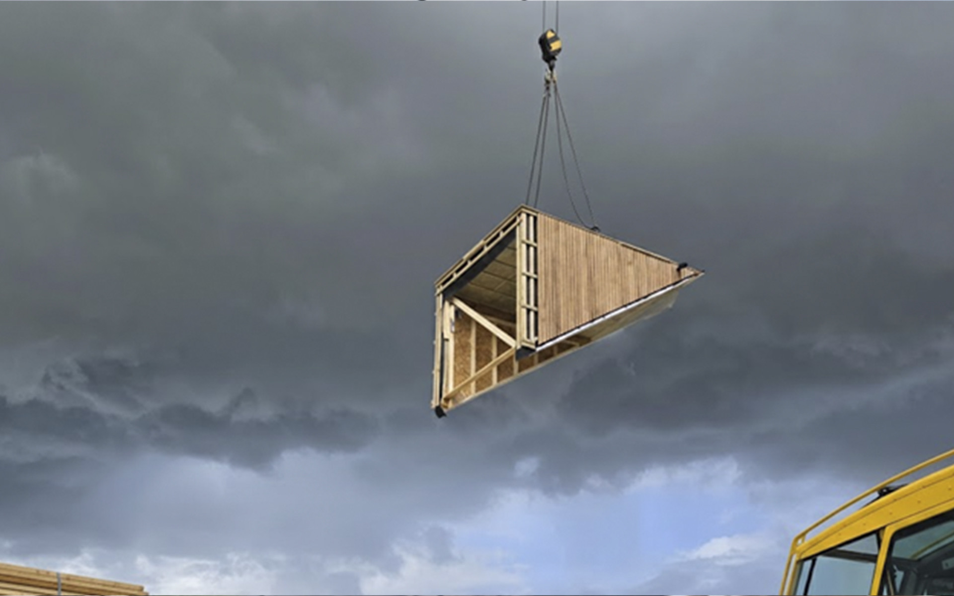 Crane lifting prefabricated timber room module on construction site using lifting equipment for wooden prefabricated buildings 